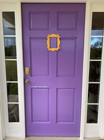 a purple door with a handmade yellow frame around the peephole