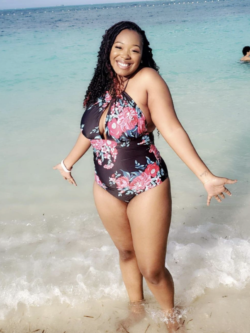 reviewer wearing the swimsuit in black and pink floral