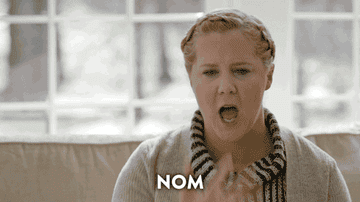Amy Schumer licking her fingers and saying, &quot;nom nom nom nom&quot;