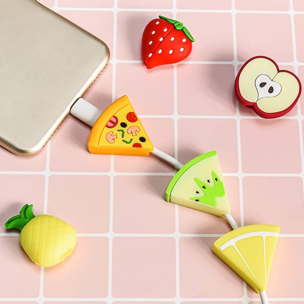 a cellphone with a pizza, apple, and lemon cord charm