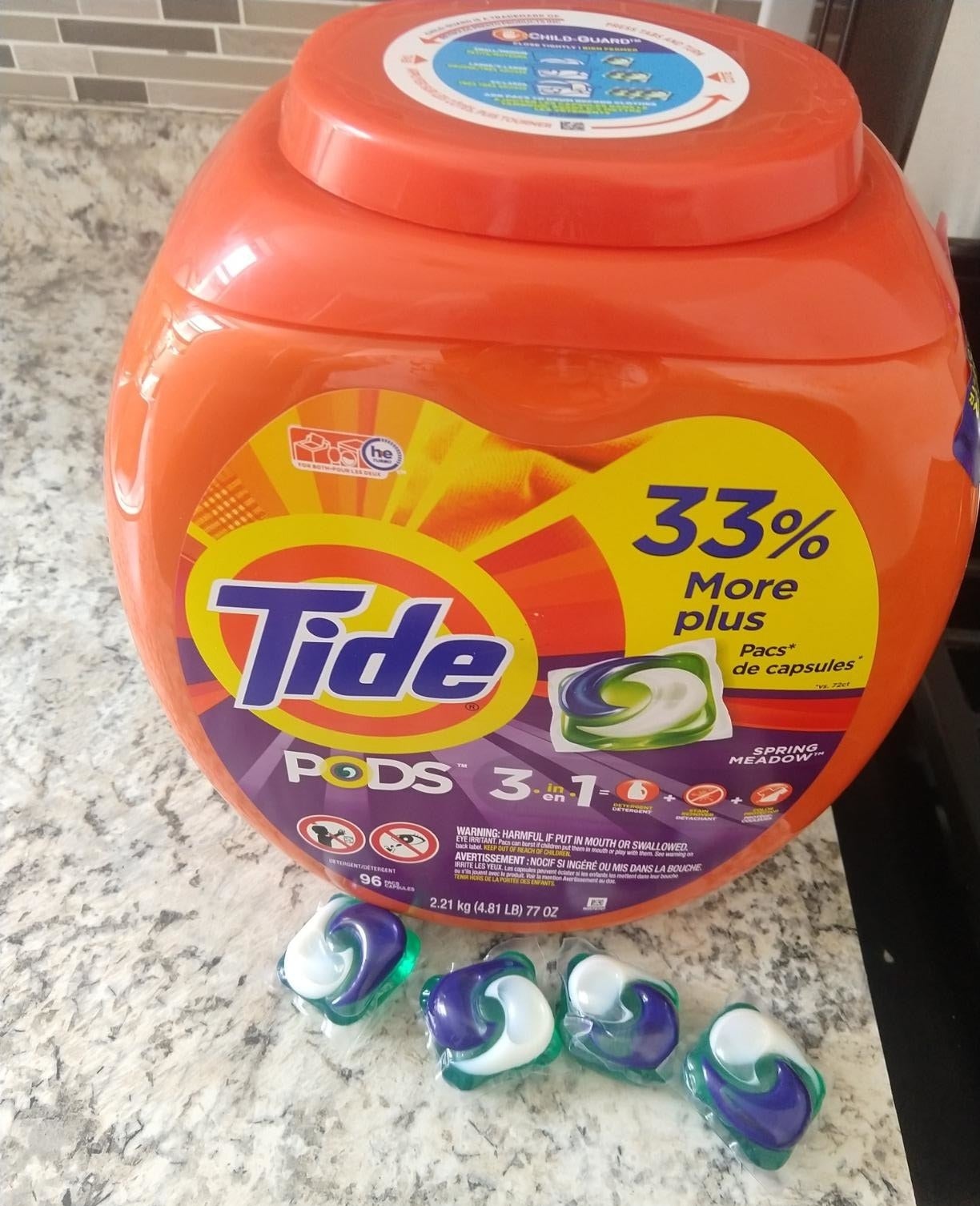 reviewer&#x27;s container of tide pods with four pods next to it 