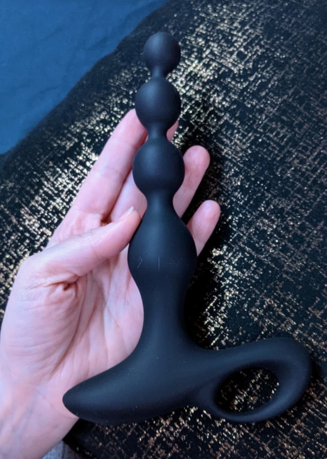 image of reviewer holding the vibrating anal beads butt plug in their hand