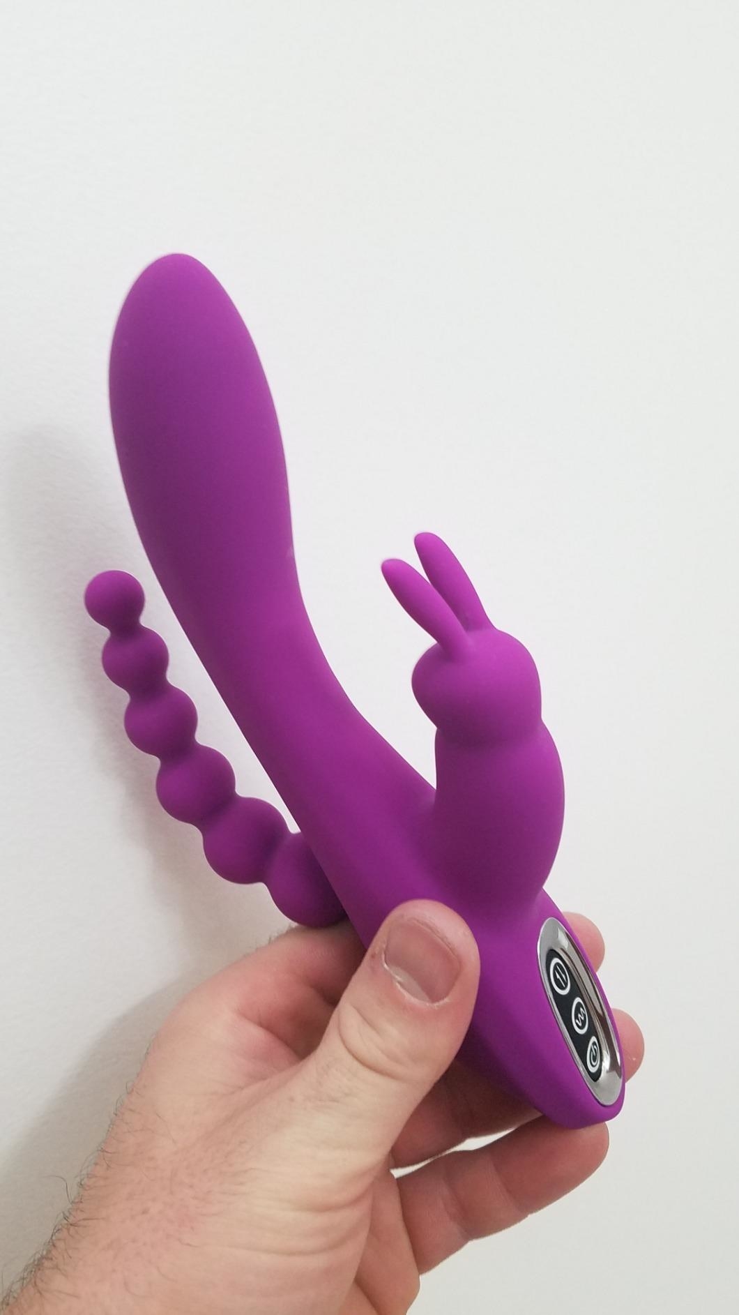 image of reviewer&#x27;s hand holding up the 3-in-1 g-spot rabbit anal dildo vibrator