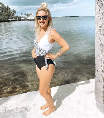 reviewer wearing swimsuit in white, black, and snake skin print color block