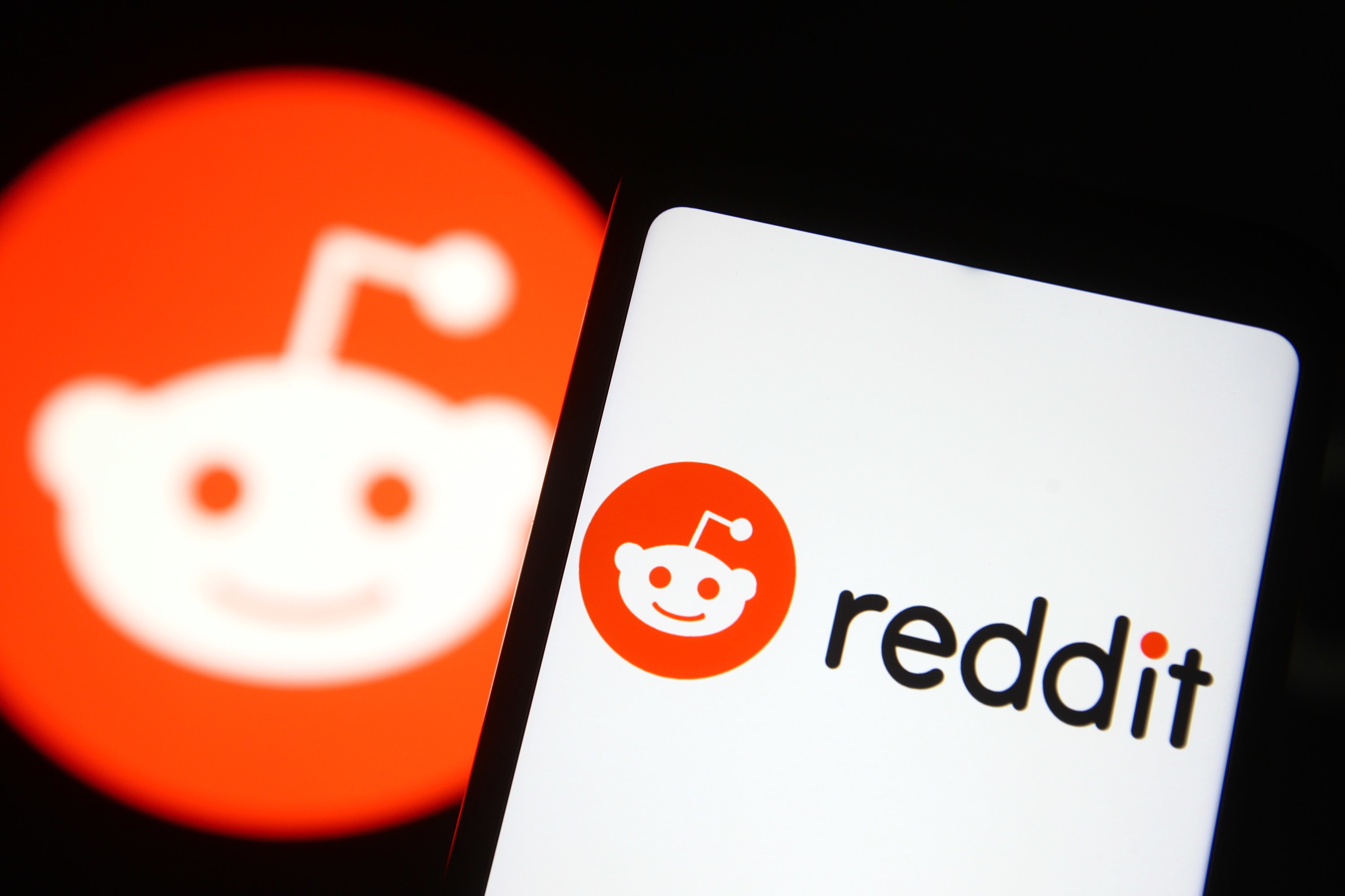 A smartphone with the Reddit app loading, showing the logo