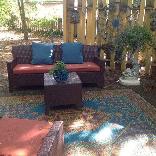 outdoor room with patio furniture with printed rug on the patio surface