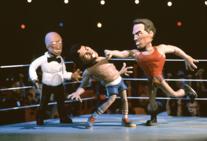 A photo of claymation versions of Sylvester Stallone being punched by Arnold Schwarzenegger in a boxing ring