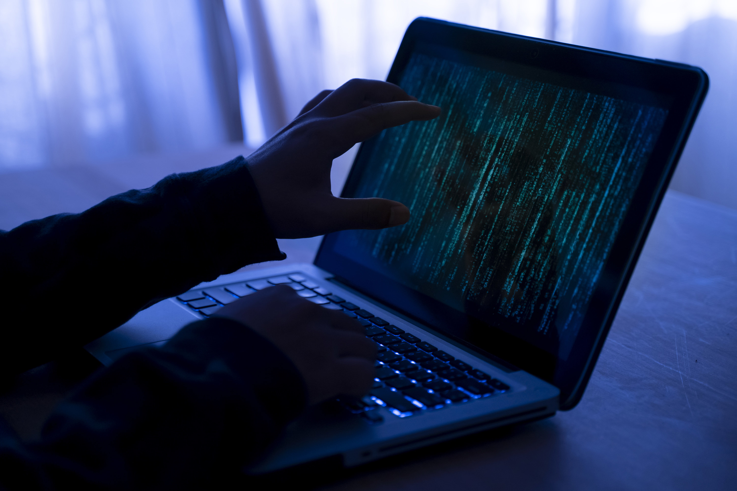 Hacker using a dark laptop