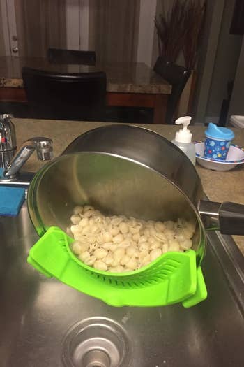 the green strainer draining a pot of pasta