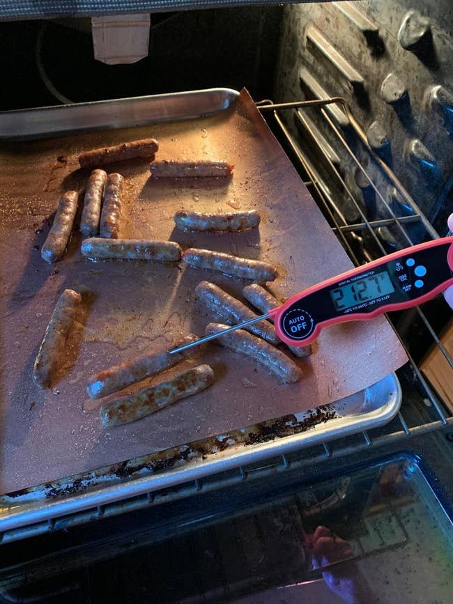 image of reviewer using the red meat thermometer to check the temperature of oven-baked sausages