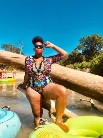 reviewer wearing the short-sleeved zip-front swimsuit in a multicolored graphic pattern