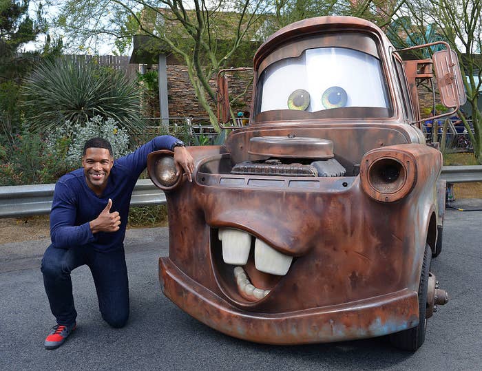 Michael smiling and posing with Cars movie character Tow Mater
