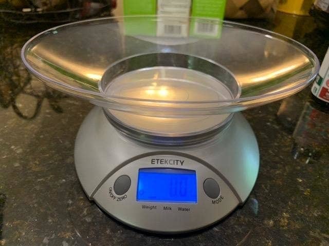 reviewer image of the etekcity digital scale on a dark marble countertop