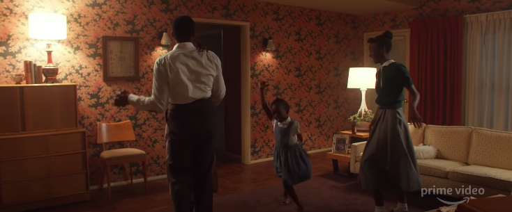 A Black family dances in their living room.