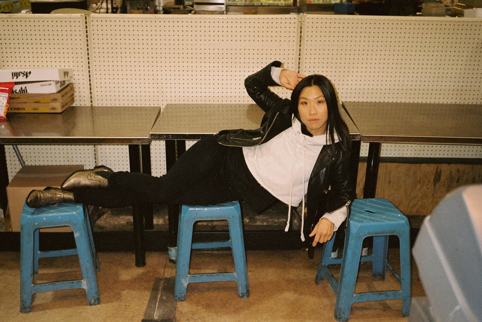 A woman lying on a series of stools