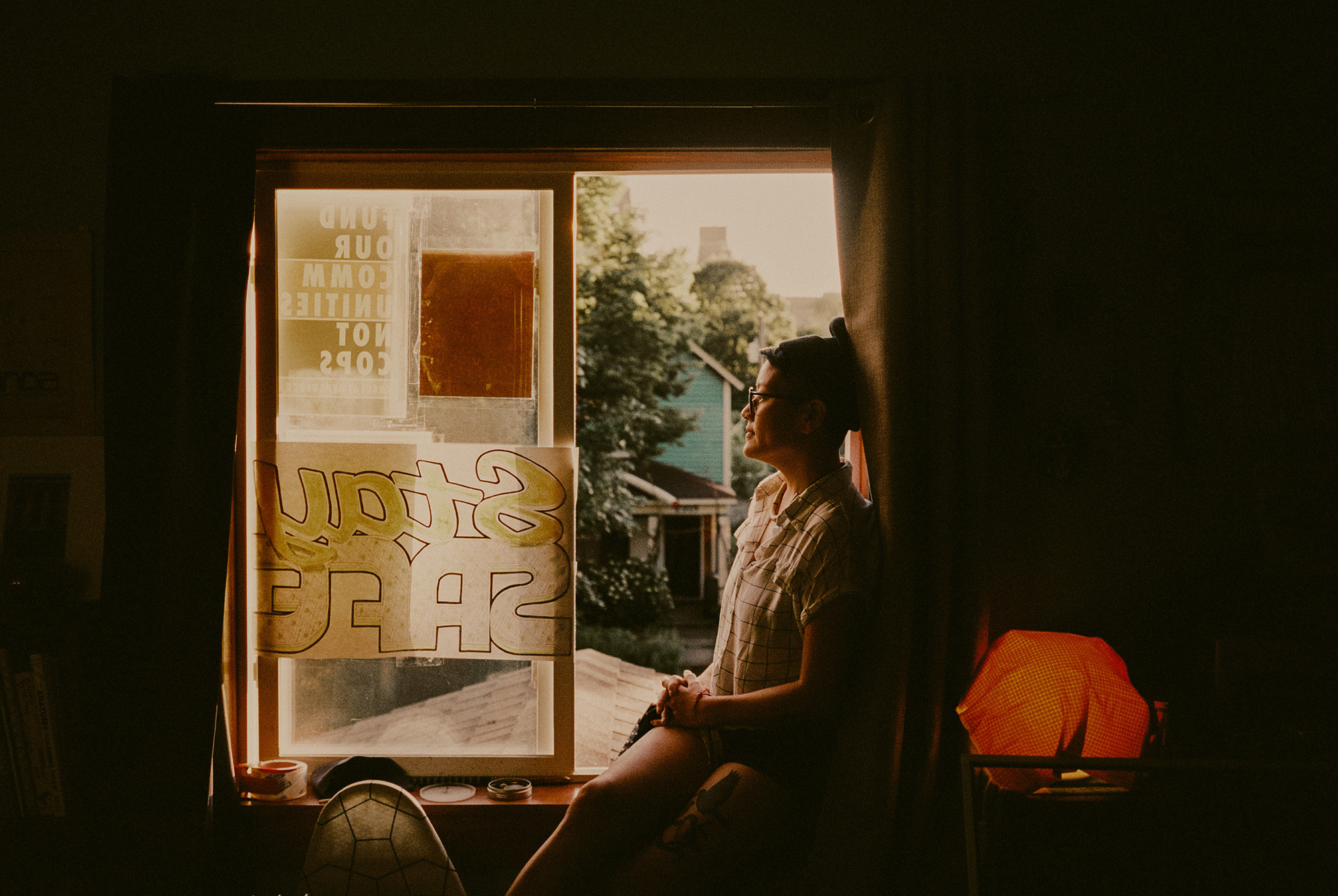 A woman sitting on a rooftop looking out 