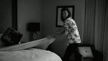 Harry Styles of One Direction stripping sheet off bed