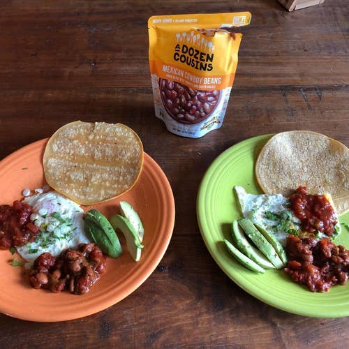 reviewer's bag of pinto beans and some on a plate with avocado, tortillas, and cheese