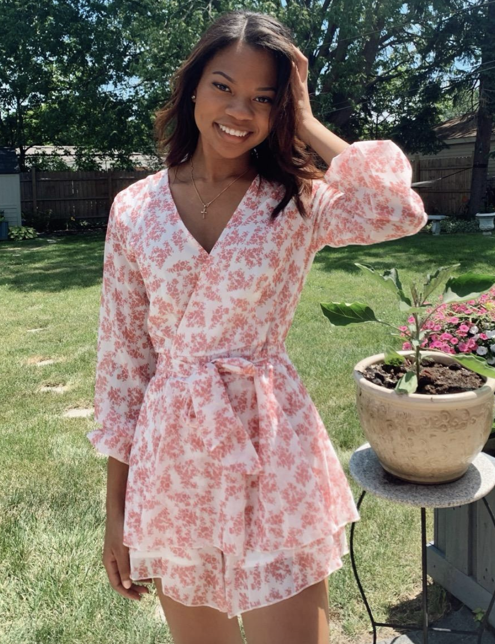 reviewer wearing the white and pink floral romper 