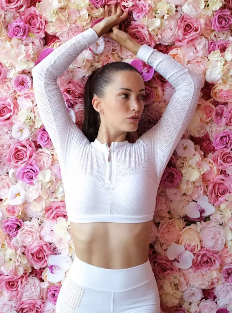 the model in the white long-sleeved crop top