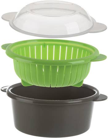 the three pieces of the steamer: gray bowl, green colander, and clear lid