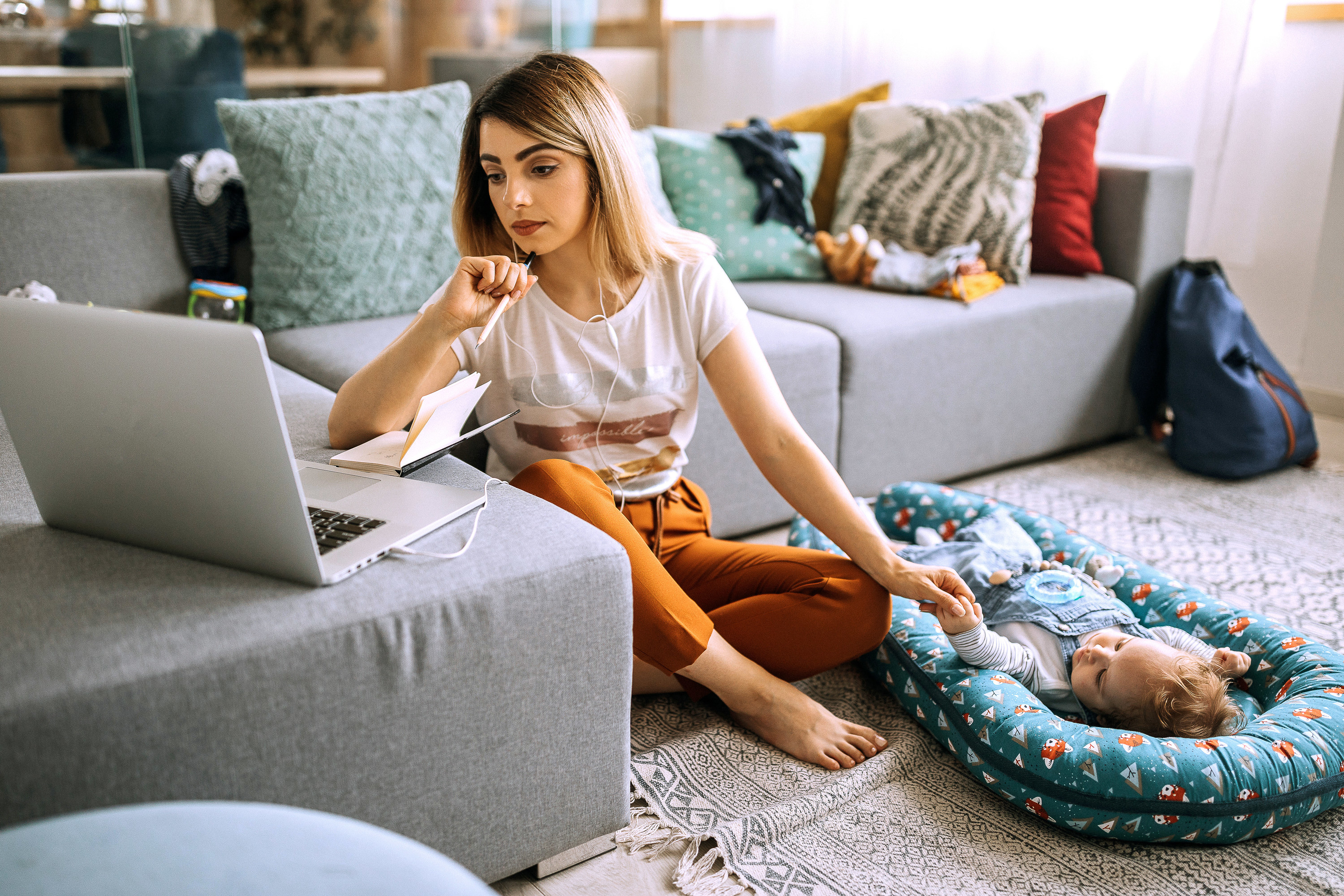 Young mom looking at her budget with baby beside her