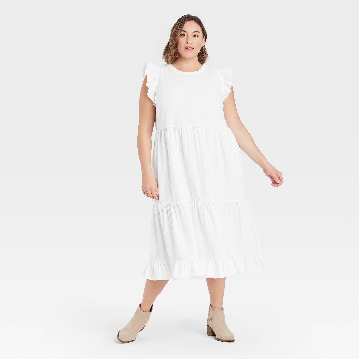Model in white sleeveless tiered dress