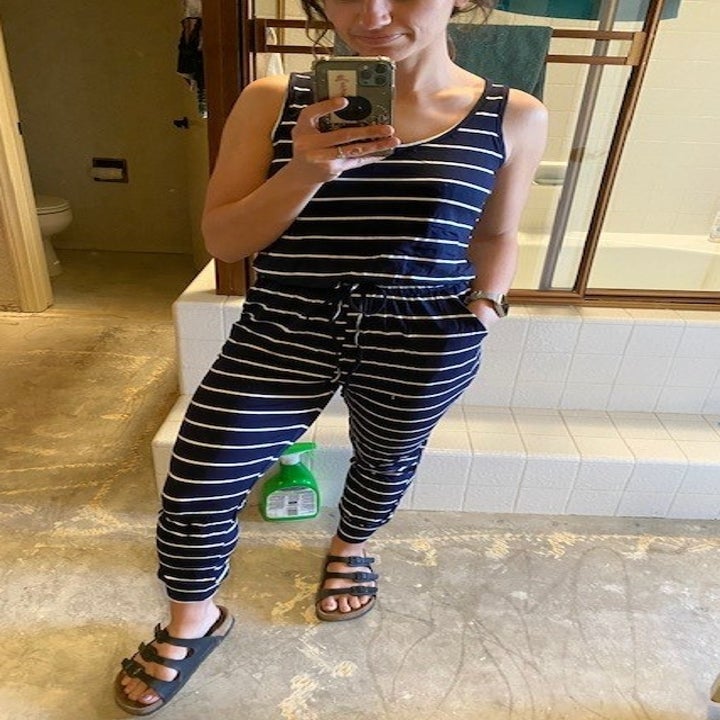 a reviewer photo of the jumpsuit in navy and white striped