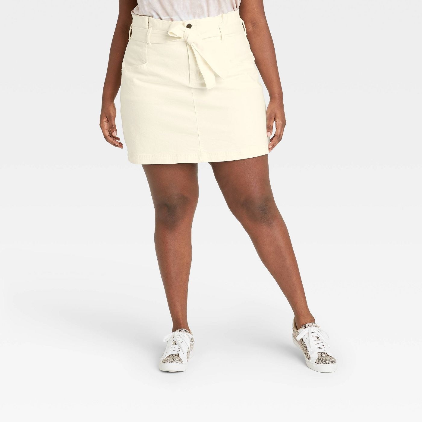 Model in high-rise tie-waist denim mini skirt