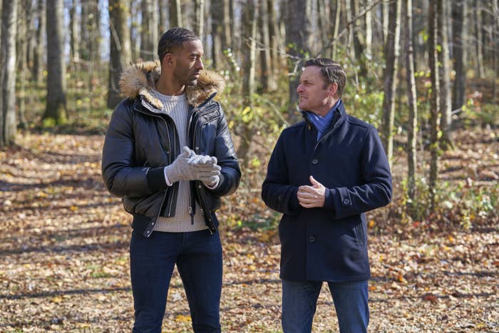 Matt James and Chris Harrison talking to each other in a wooded area