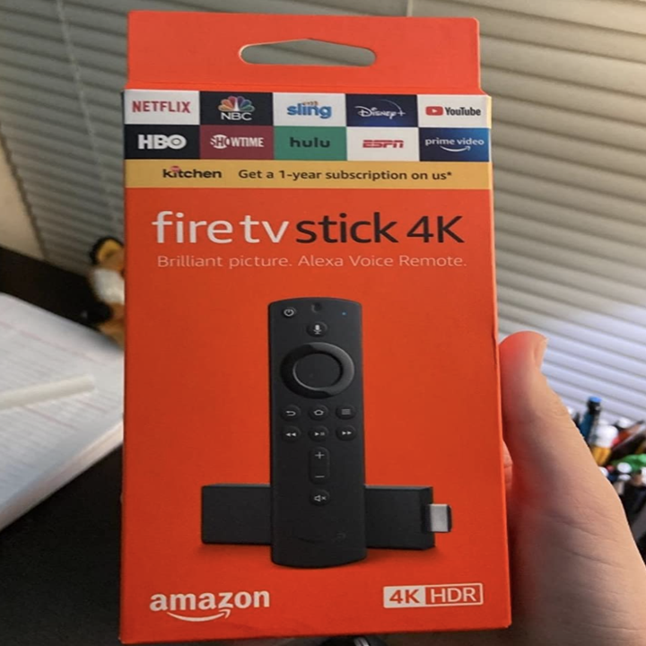 A customer review photo of them holding the box of the Fire TV Stick