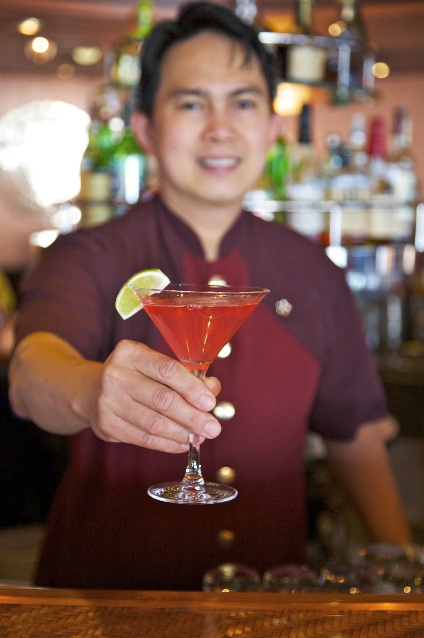a bartender passing over a pink martini