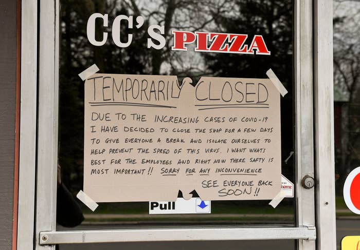 Pizza shop window with sign that says temporarily closed due to Covid-19