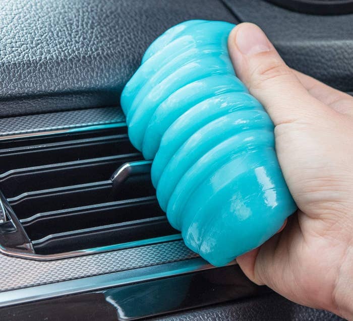 a blue putty being pressed into a car air vent