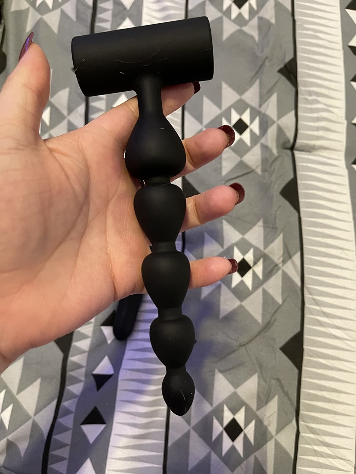 reviewer image of a hand holding the anal beads butt plug