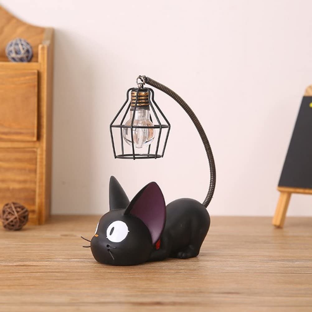 the cat-shaped lamp with the light hanging from the end of the black cat&#x27;s tail