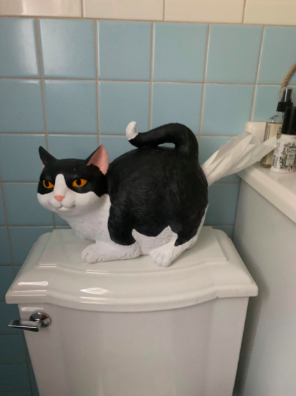a reviewer photo of the cat-shaped tissue holder in a bathroom