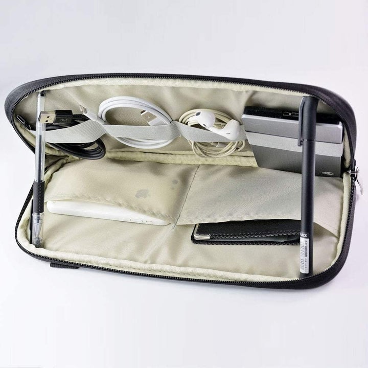 the visor organizer open to show compartments inside holding wires and chargers