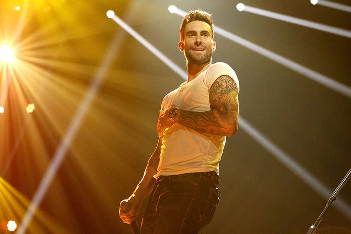 Adam smiling and performing on stage