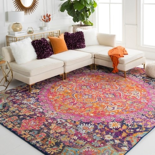 the bright pink, purple, orange, mint, and white floral pattern rug in a living room 