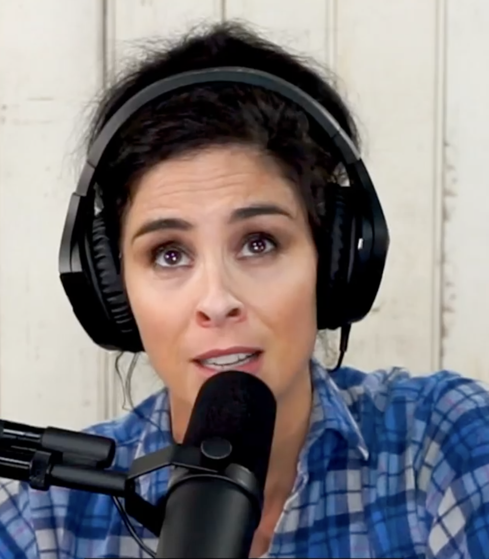 Sarah speaking into the microphone while recording her podcast