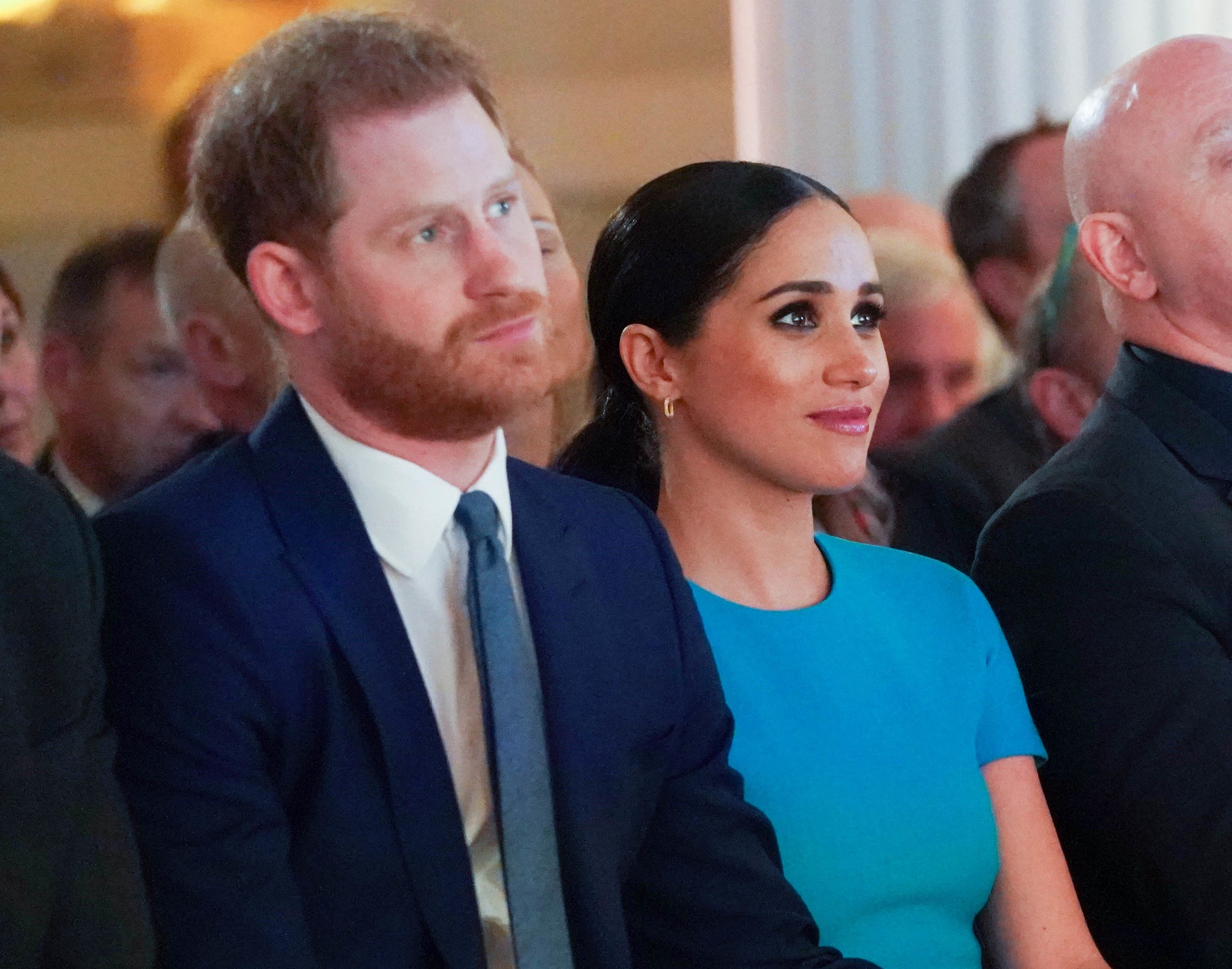 Meghan and Harry sit together at an event