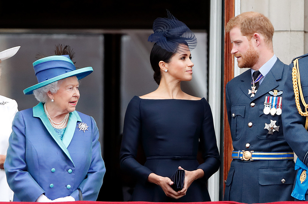 Meghan and Harry look at each other while standing next to the Queen at an event