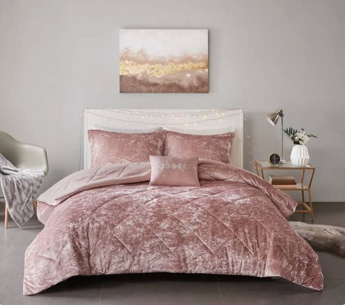 Rose colored crushed velvet comforter set on white bed