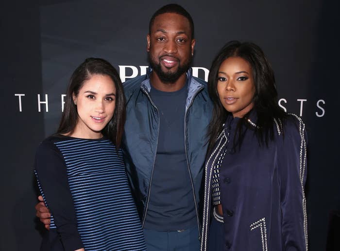 Meghan poses with Gabrielle Union and her husband at an event 