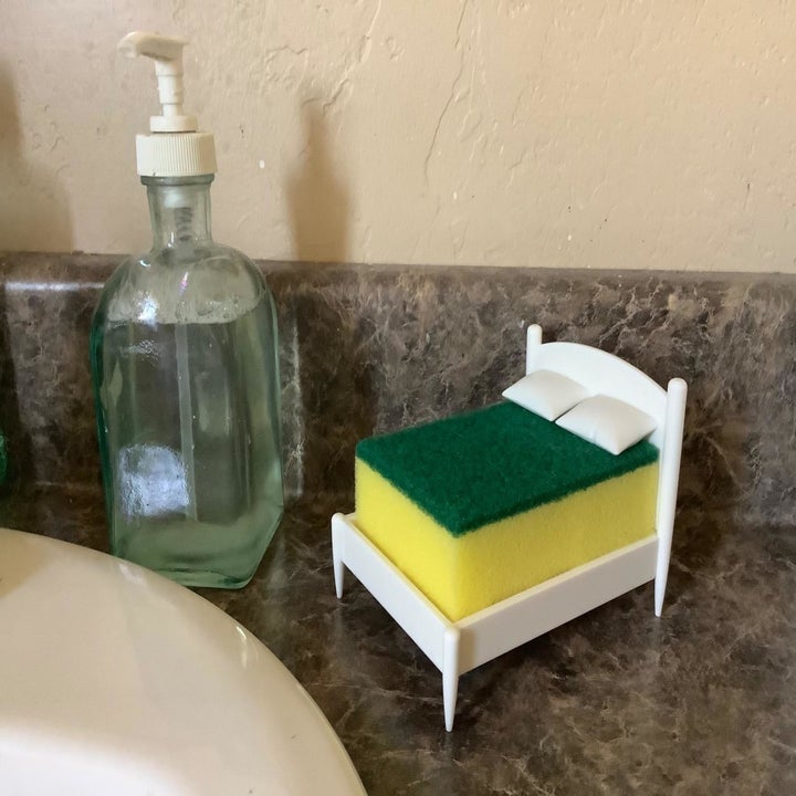Reviewer photo of bed-shaped sponge holder placed on kitchen sink