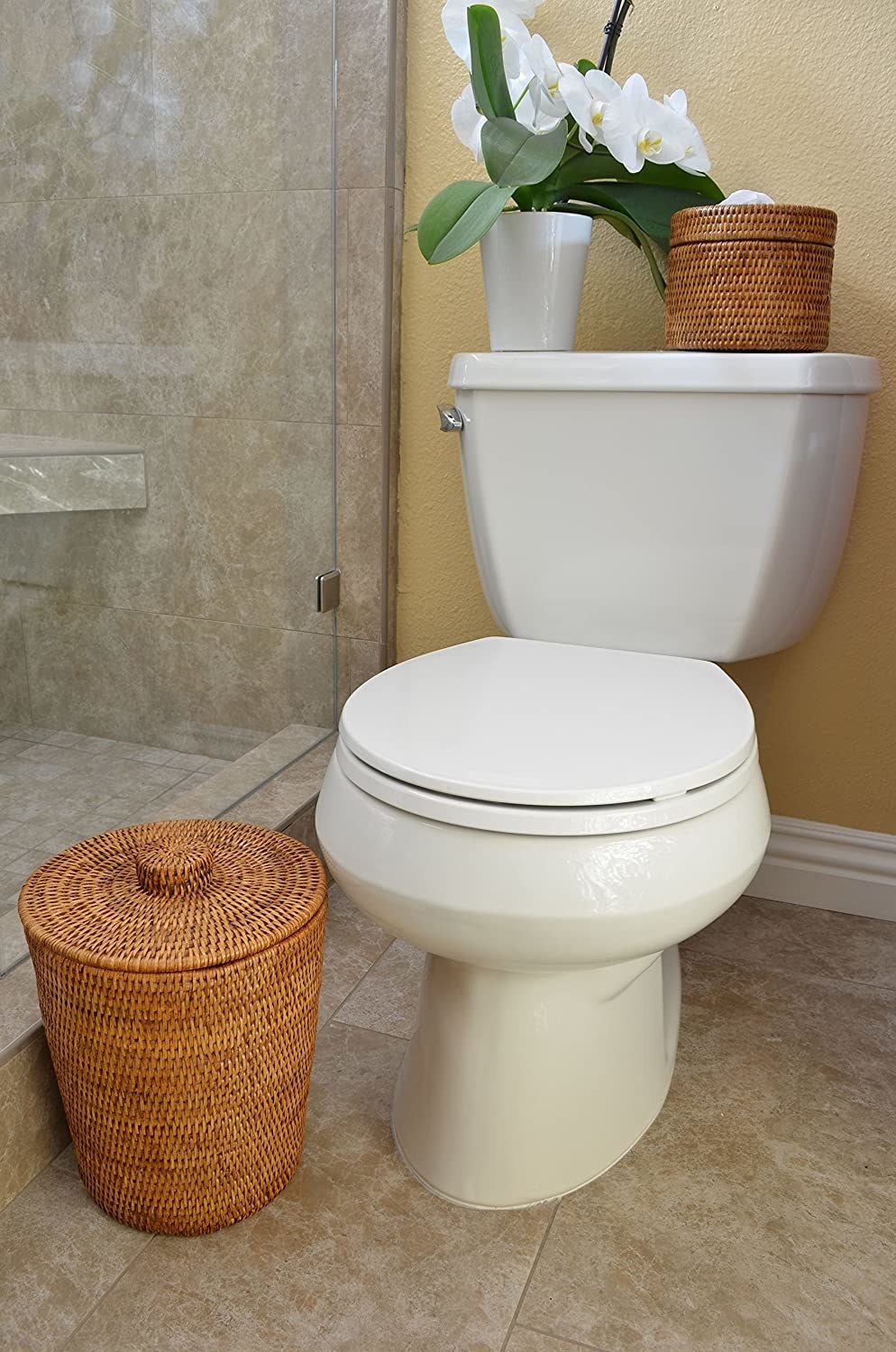 the kouboo la jolla rattan round waste basket next to a toilet in a bathroom