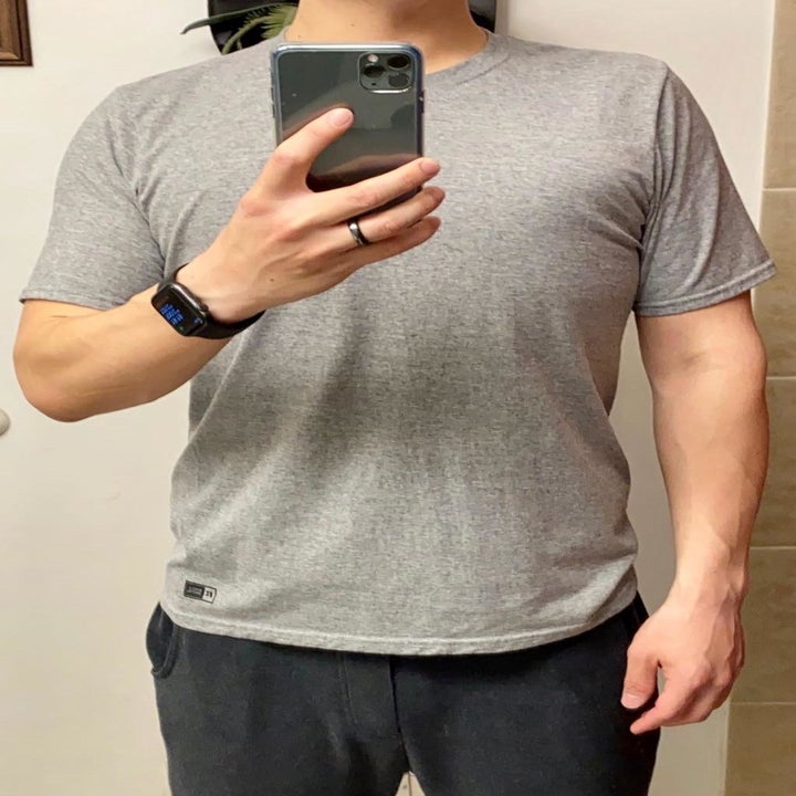 reviewer taking a selfie while wearing the grey athletic shirt