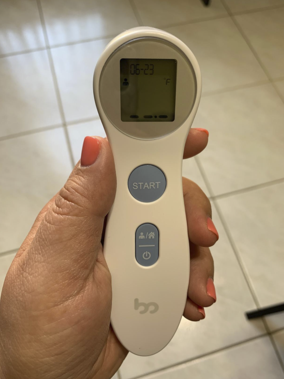 reviewer&#x27;s hand holding the thermometer