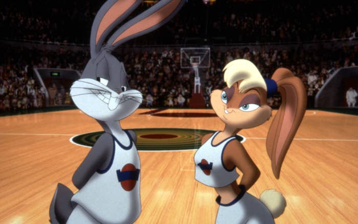 The original Lola Bunny wearing a midriff-baring basketball jersey, eyeshadow, and her ears pulled into a ponytail while standing next to Bugs Bunny on the basketball court